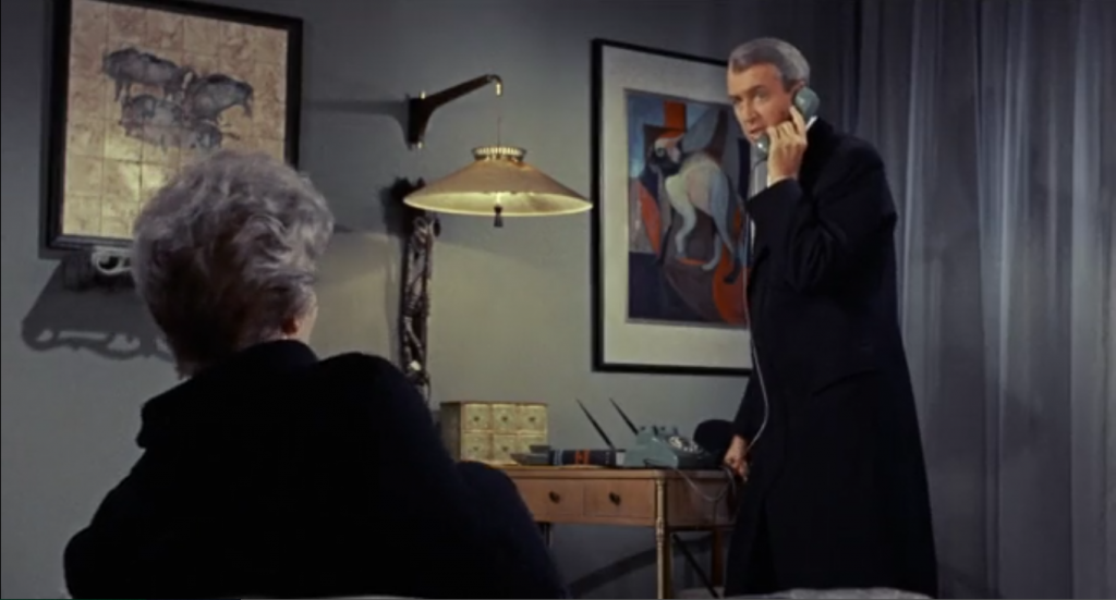The cat painting can be seen behind James Stewert as he makes a call in Gillian's (Kim Novak) apartment